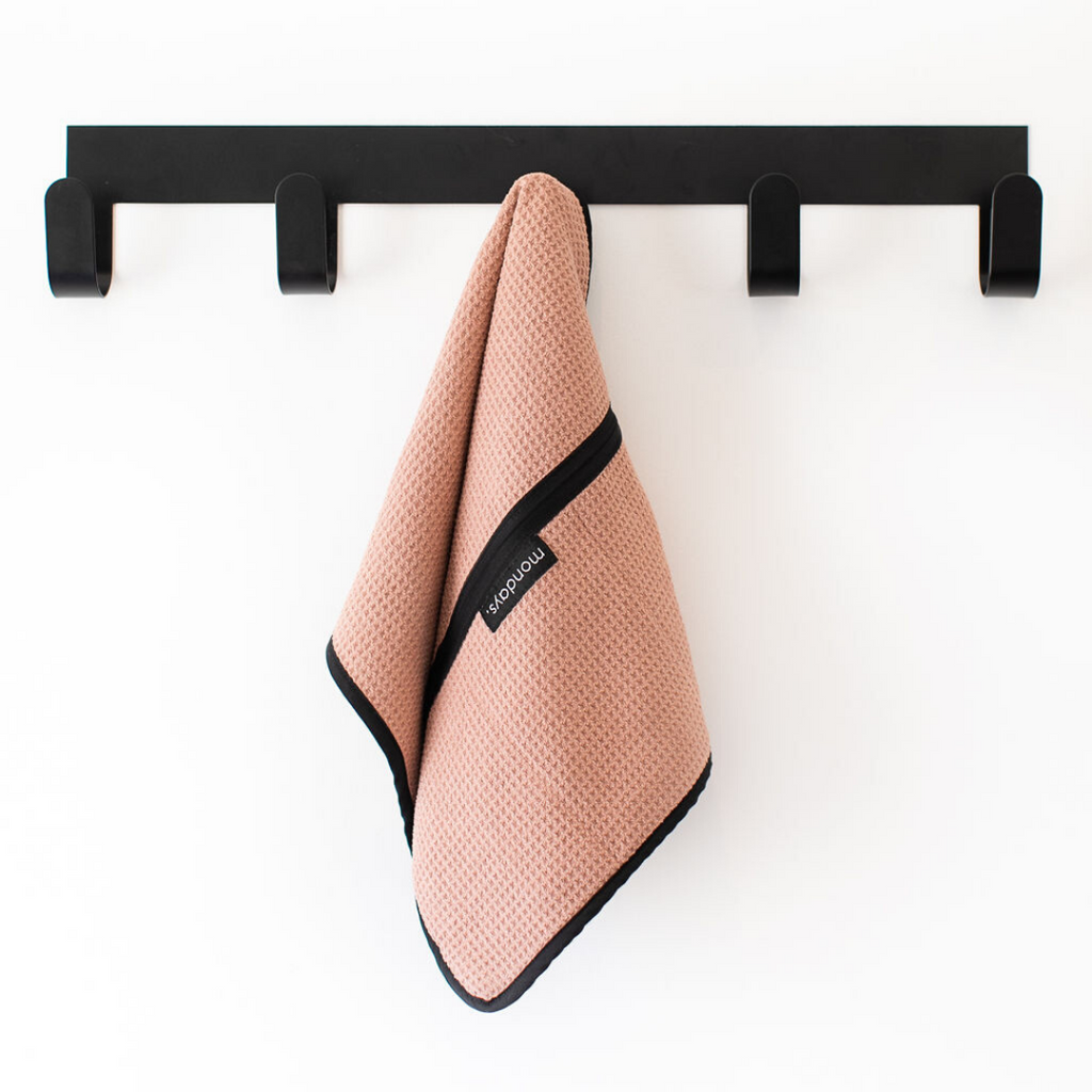 Pink microfiber gym towel hanging on a hook